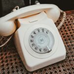 white and beige rotary telephone