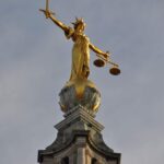 gold statue of man holding sword