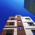 looking up at a tall brick building with windows