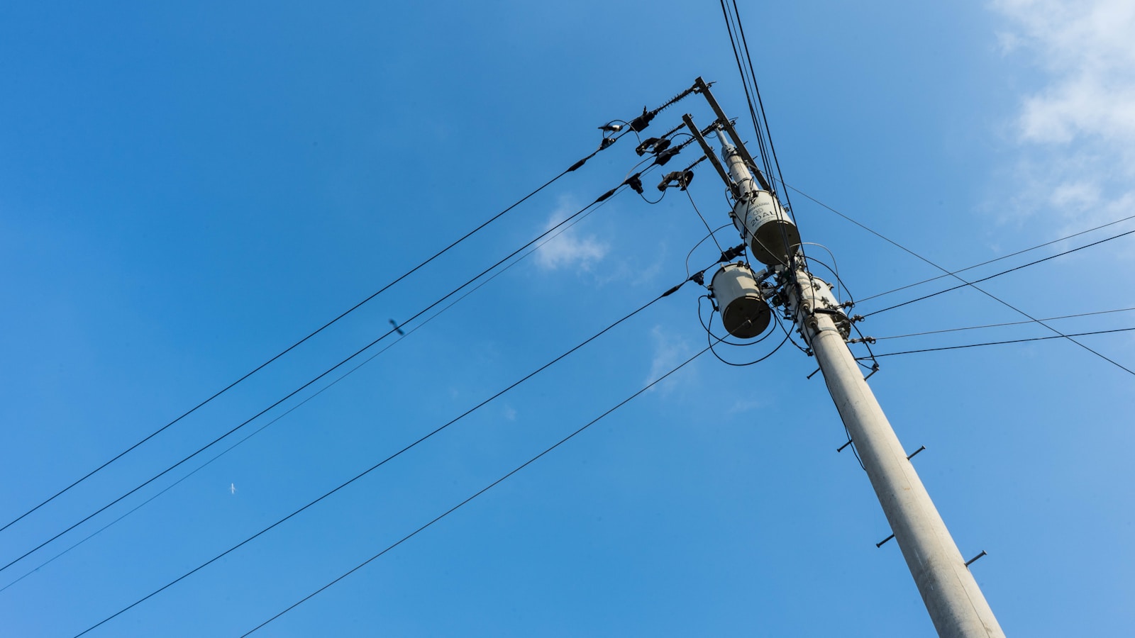 a pole with many wires and a sky background