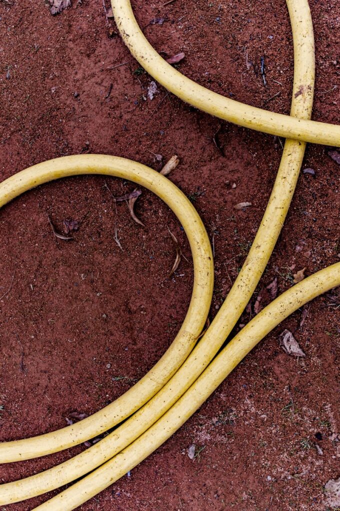 a couple of yellow hoses laying on the ground
