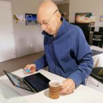 man in blue sweater using macbook pro