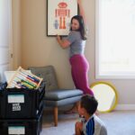woman in gray shirt and pink pants sitting on gray chair