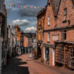 A street lined with tall brick buildings under a cloudy sky