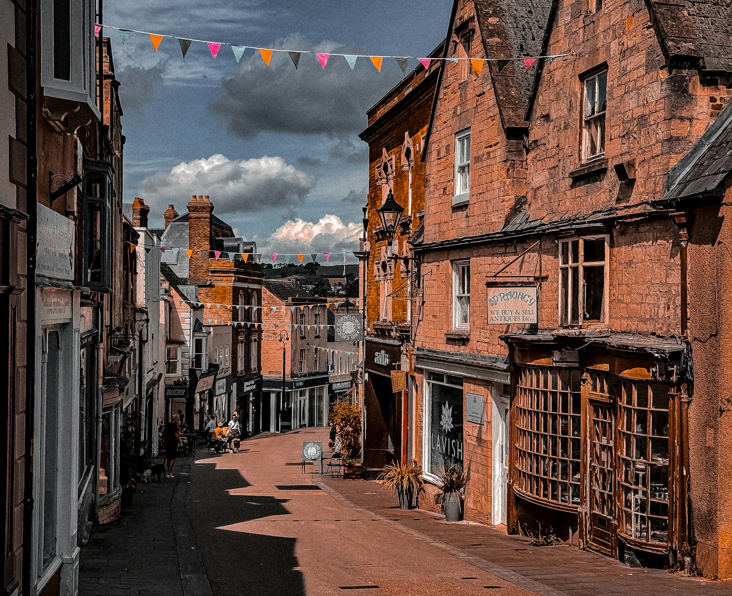 A street lined with tall brick buildings under a cloudy sky