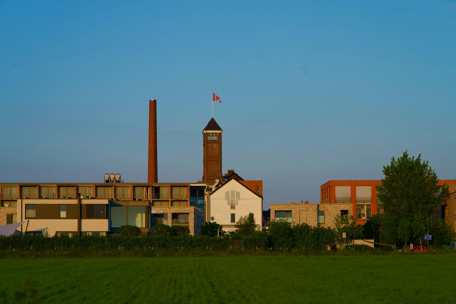 a building with a clock tower in the middle of a field