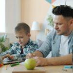 Father and son working together on a laptop.