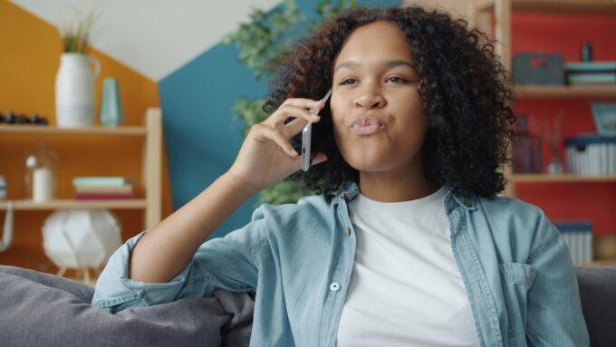Young woman talking on a cell phone at home.