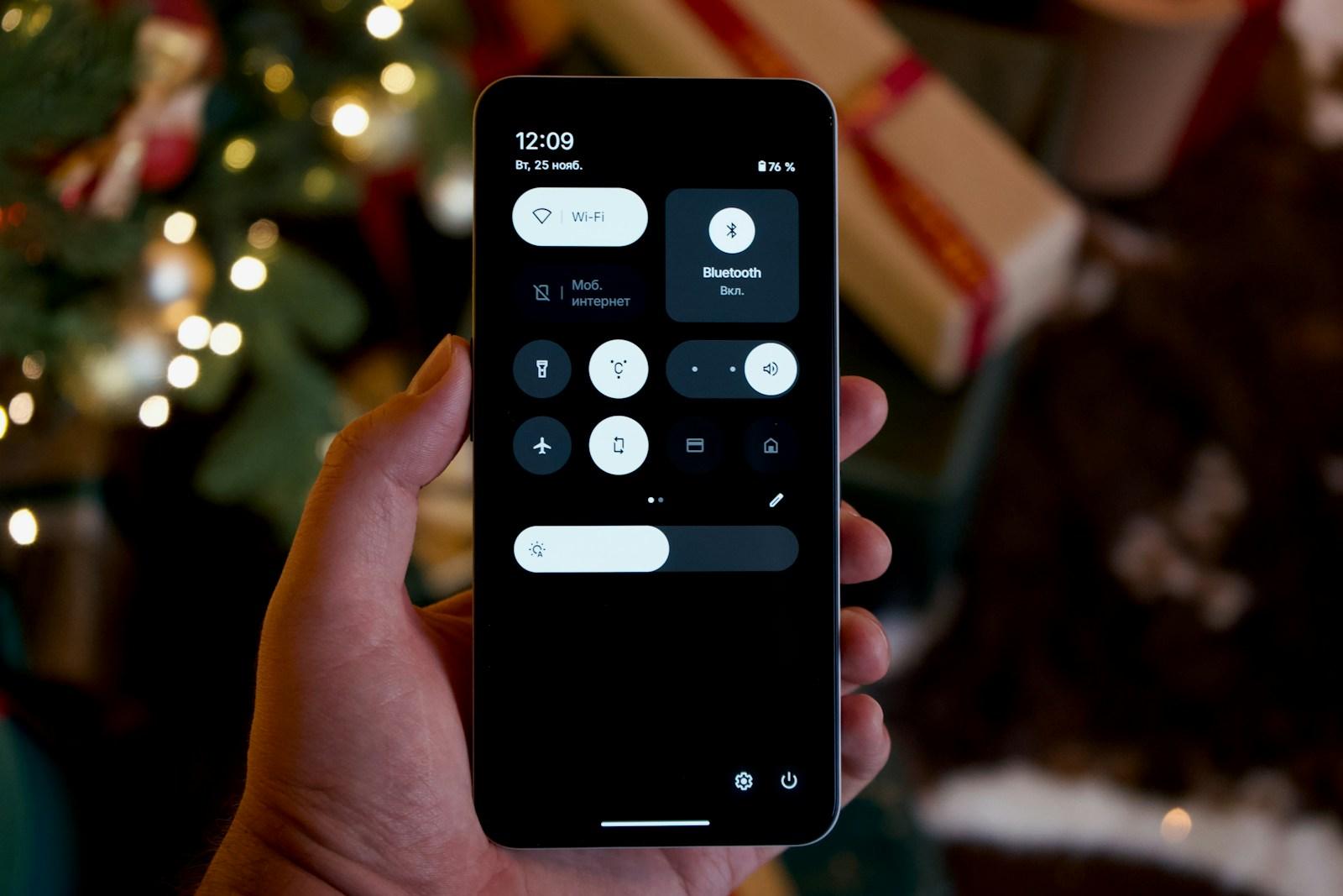 Hand holding a smartphone with a dark interface.