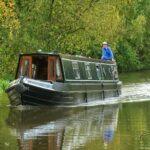 a man standing on top of a boat on a river
