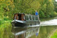 a man standing on top of a boat on a river