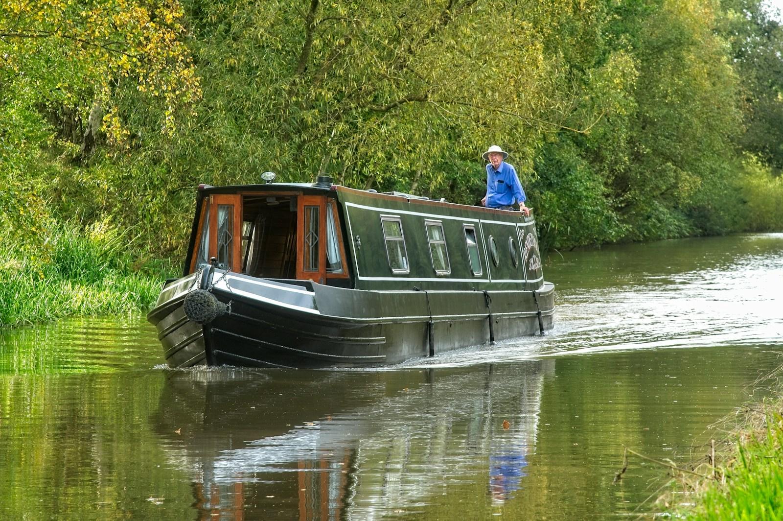 a man standing on top of a boat on a river