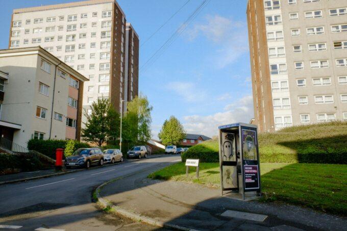 Apartment buildings and street with a phone booth.