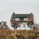 a house on the beach next to some trees