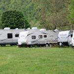 white and brown rv trailer on green grass field during daytime