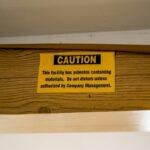 A caution sign is posted on a wooden shelf
