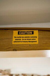 A caution sign is posted on a wooden shelf