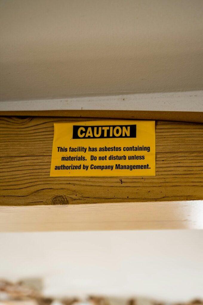 A caution sign is posted on a wooden shelf