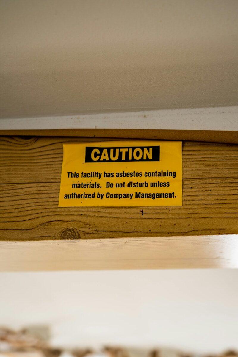 A caution sign is posted on a wooden shelf