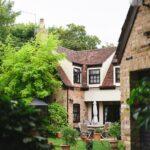 A large house with a lot of greenery in front of it